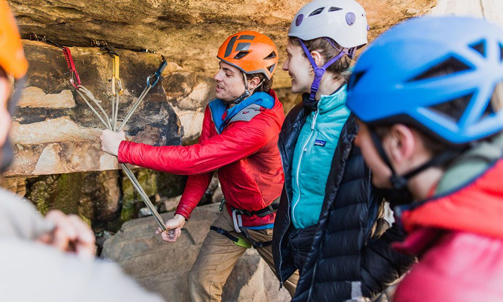 Blog - Gym to Crag Risk Management with Granite Insurance - Climbing Instructor Demonstrating Climbing Tips With A Class