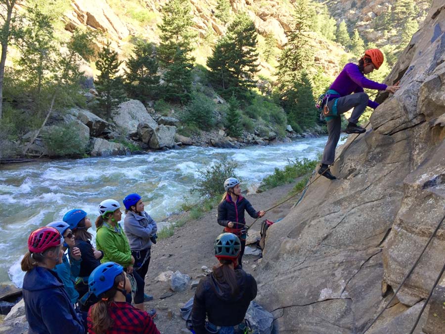 Blog - Gym to Crag Risk Management with Granite Insurance - Climbing Student Climbing Up A Rock Outside With The Class Watching