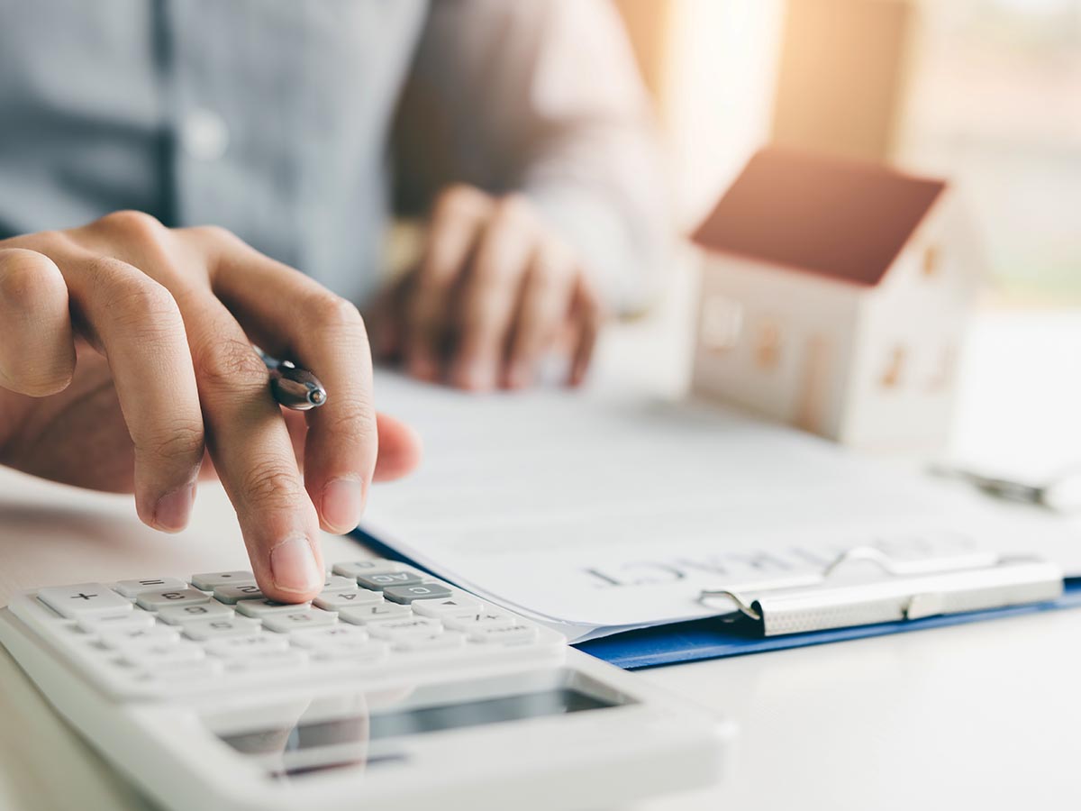 Man using calculator while looking at insurance documents