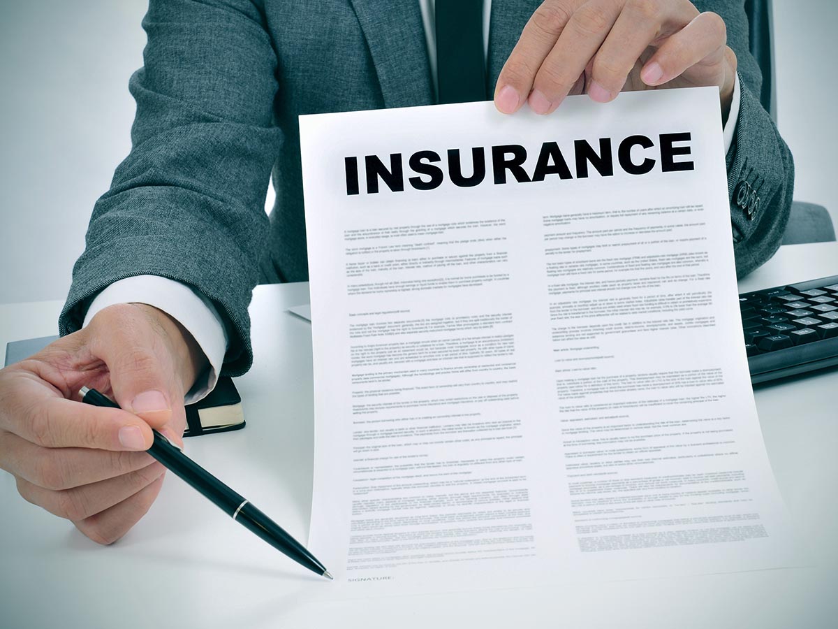 Business man holding up an insurance document