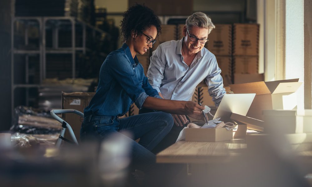 man and woman together looking at a piece of paper in an office setting